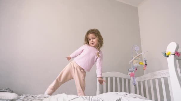 Infância feliz para a menina criança que pulando na cama — Vídeo de Stock