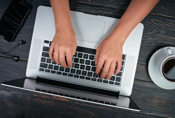 Mãos de mulher com laptop, smartphone e café . — Fotografia de Stock
