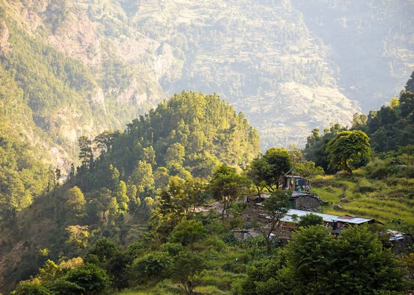 Pequena aldeia nepali tradicional nas montanhas em luzes de pôr do sol . — Fotografia de Stock