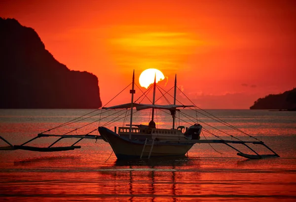 Barco filippino tradicional en la bahía de El Nido con luces de puesta de sol . Imágenes De Stock Sin Royalties Gratis