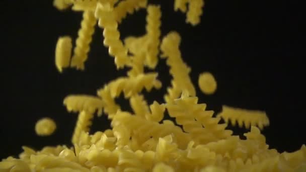 Italian fusilli falling. Spirelli pasta on dark background. Slow motion shot — Stock Video