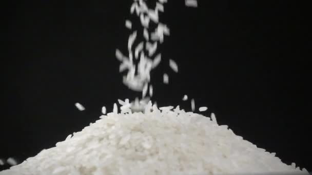 Pouring rice over black background — Stock Video