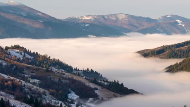 Morgondimman försvinner i höstens vinterfjäll. Landskap med snöiga berg och rinnande dimma. Zooma ut, 4k — Stockvideo