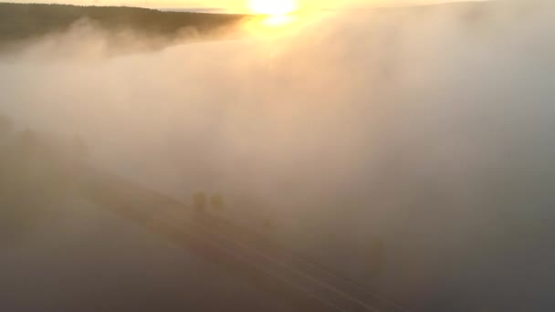 Volando a través de las nubes en las luces del sol de la mañana. Paisaje finlandés con río y bosque, vista aérea — Vídeos de Stock