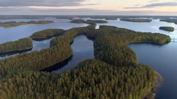 Voando sobre a terra do lago na Finlândia. Tiro aéreo de muitas ilhas verdes no pôr do sol - paisagem finlandesa clássica. 4K, UHD — Vídeo de Stock