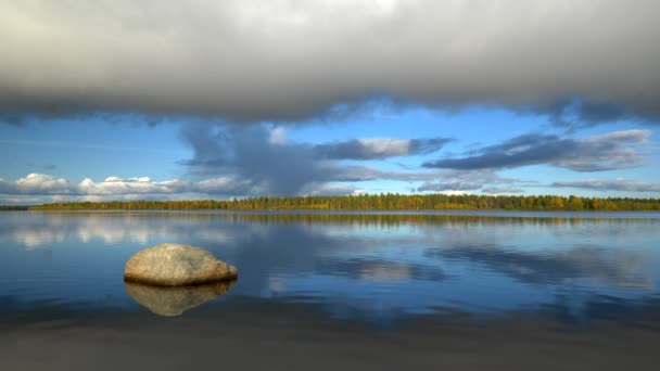 Paisaje zen con piedra, lago, árboles otoñales y nubes. Norte de Finlandia, Laponia. 4K, UHD — Vídeo de stock
