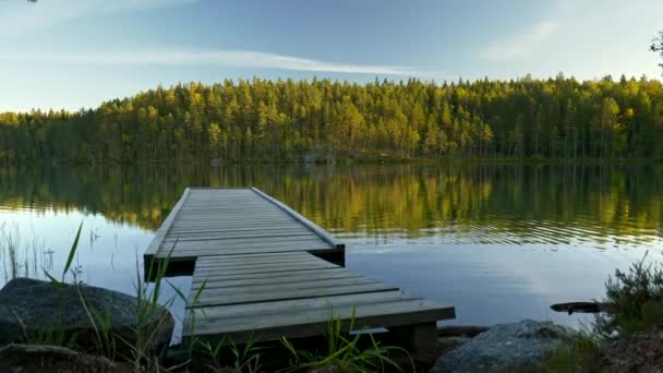 Quai dans le parc national de Repovesi, Kouvola, Finlande. Steadicam prise de vue de la jetée et du lac avec des reflets au coucher du soleil. 4K, UHD 
