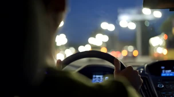 O homem conduz um carro na cidade nocturna e ouve música. Vista preta — Vídeo de Stock