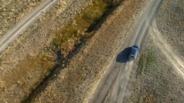 Dusy Yolu 'nda tanınmayan bir SUV aracı. Kırsal toprak yolda gri bir arabanın üzerinden uçuyor. Hava görünümü — Stok video