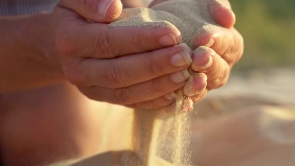 Handen van een vrouw met wit zand. Vrouwelijke giet zand in zonsondergang lichten. Slow motion shot — Stockvideo