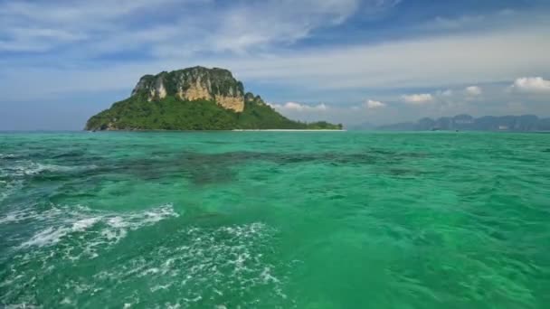 Проплывая залив на лодке, мимо островов в Индийском океане, Таиланд. Бирюзовые воды Андаманского моря чистые и прозрачные. Живописное голубое облачное небо. 4K — стоковое видео