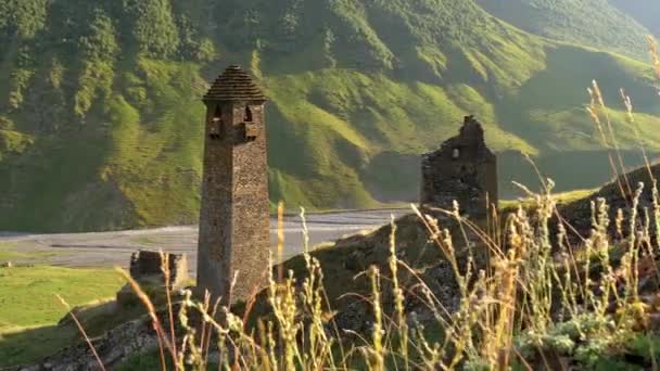 Torre Tusheti velha e ruínas no sopé das montanhas do Cáucaso em Tusheti, Geórgia, perto da aldeia de Dartlo. Um riacho de montanha quase seco é visto no fundo. Steadicam, 4K — Vídeo de Stock