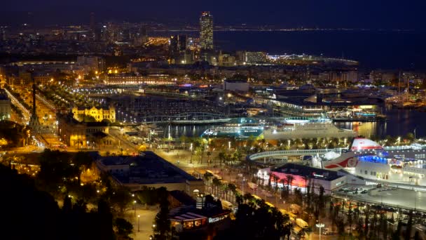 Coches que van por las calles de la noche Barcelona, España. Los barcos están amarrados por la orilla. La ciudad está brillando con luces amarillas de noche. El agua del mar Mediterráneo y el cielo parecen ser de color púrpura. 4K — Vídeo de stock