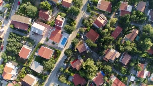 Yeşil bitki örtüsüyle çevrili yüzme havuzları olan tek kişilik aile evleri ve villaların üzerinde uçuyorlar. Yukarıdan aşağıya doğru çekim, Uhd — Stok video