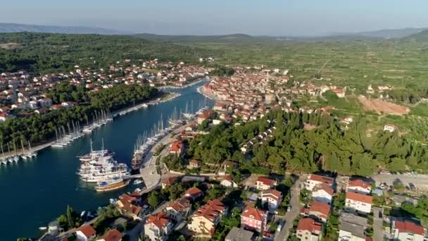 Летит над Стари Град, Хвар, Хорватия. Белые лодки и яхты пришвартованы у берега. Стари Град означает старый город на хорватском. Воздушный, 4K — стоковое видео