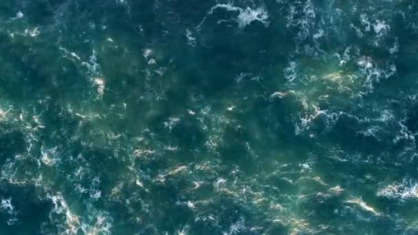 Agitant l'océan. Surface d'eau turquoise mousseuse scintillante de lumière dorée. Plan aérien du haut vers le bas, 4K 