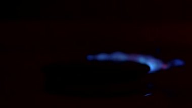 Mutfakta doğal gaz alevleniyor. Gaz sobasında yanan mavi alevler. Yavaş çekim.