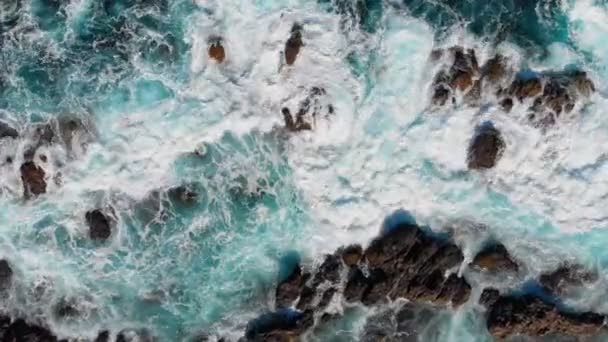 Golven breken op stenen. Wave schuimende en spetterende oceaan surfen. Bovenaanzicht vanuit de lucht. 4k, Uhd — Stockvideo