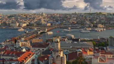 İstanbul, Türkiye 'ye zoom yap. Galata Kulesi 'nden İstanbul şehir merkezinin gün batımı manzarası. Feribotlar Galata Köprüsü yakınlarındaki Golden Horn Körfezi boyunca yelken açıyor.