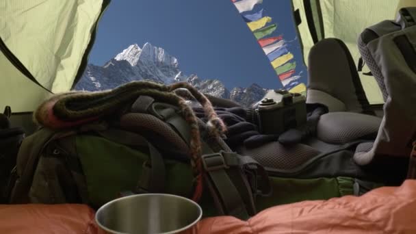 Kamp çadırında. Dağlardaki çadırlarda seyahat ekipmanları. Uyku tulumu, sırt çantası, bardak ve film kamerası. Çadırdan dağ manzarası. Nepal, Himalayalar dağları — Stok video