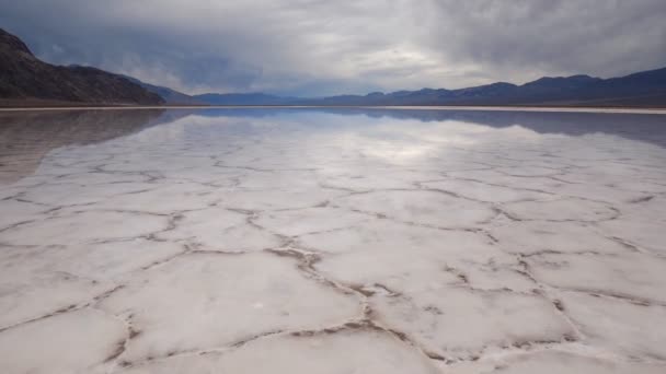 Volando sobre la superficie del espejo de formaciones de corteza salina con agua en Badwater Basin, Parque Nacional del Valle de la Muerte. California, Estados Unidos . — Vídeos de Stock