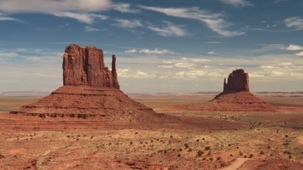 Снимок Монумент-Вэлли, Аризона, США. Причудливые скальные образования под голубым небом в Monument Valley, UHD, 4K — стоковое видео
