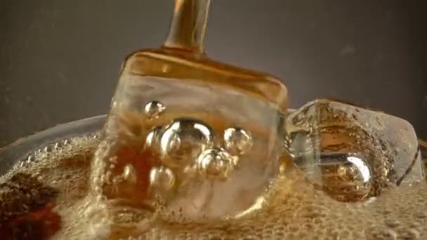 Verter Cola en vaso con hielo. Super macro shot. Vidrio giratorio con bebida gaseosa de cola. UHD, 4K — Vídeos de Stock