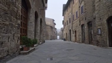San Gimignano 'nun boş caddesi ortaçağ kasabası, Toskana, İtalya. Kimse yok, hepsi karantina koronavirüs etkileri nedeniyle kapalı.