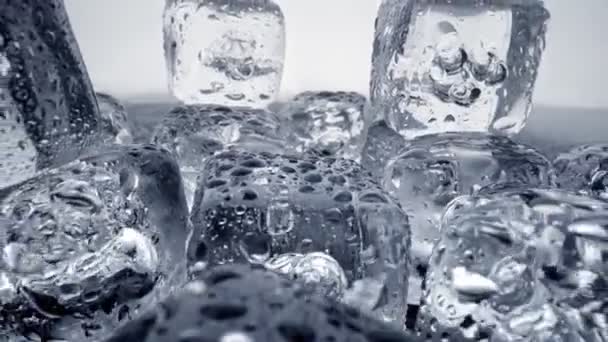 Камера удаляется от тающих кубиков льда, покрытых капельками воды. UHD — стоковое видео
