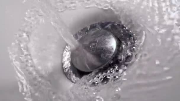Fluxo espesso de água derramando no orifício de drenagem de um tubo de banho produzindo muitas bolhas. Lento movimento close-up tiro — Vídeo de Stock