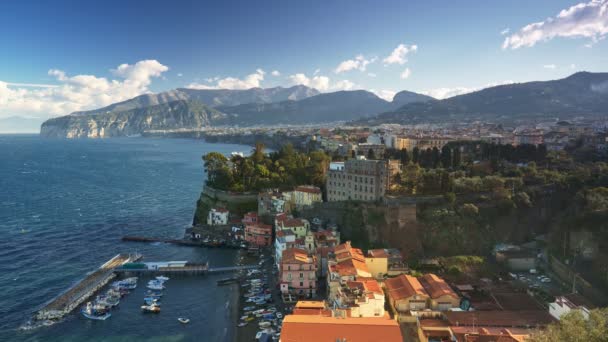 Sorrento, İtalya 'da güneşli harika bir gün. Napoli Körfezi 'nden gelen deniz kasabanın kıyılarını yıkıyor. Arka planda bir sürü ev ve dağ var. 4K — Stok video