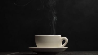 Siyah arka planda bir fincan sıcak kahve. Aroma odanın her yerine yayılır. Yavaş çekim.