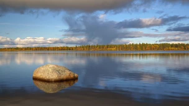 Paisaje zen finlandés. Agua fluyendo en el lago. El sol y el agua se reflejan en una piedra. Cielo pintoresco con hermosas nubes en el fondo. 4K — Vídeos de Stock
