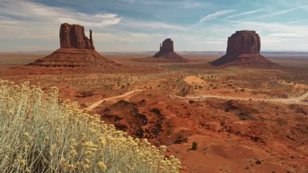 Monument Valley, Egyesült Államok. Piros sziklák és vörös föld fényes napsütésben. 4K — Stock videók