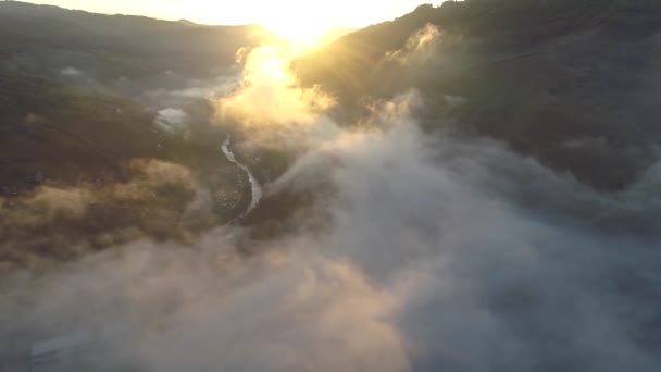 Volando por encima de las nubes por las montañas durante el amanecer. El sol brilla por todas partes, los rayos de sol atraviesan. Disparo aéreo, 4K — Vídeos de Stock