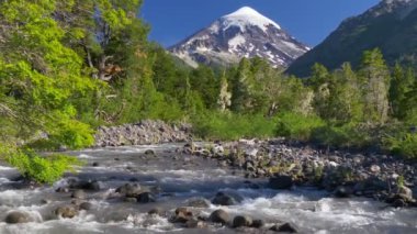 Lanin Ulusal Parkı 'ndaki Lanin volkanı. Volkan, dağ nehri ve yeşil ağaçlarla kaplı bir manzara. Arjantin, Patagonya, Göl Bölgesi