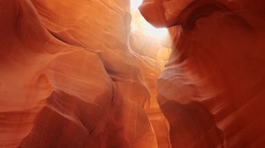 Antilop kanyonundaki toz bulutları güneşte uçuşuyor. Arizona, ABD 'deki Antilop Kanyonu' nun kırmızı duvarlarını yakınlaştır