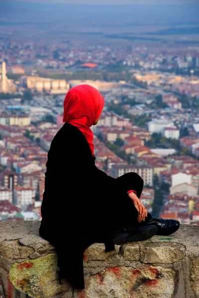 Žena sedí na vrcholu hradu při pohledu na město Afyonkarahisar — Stock fotografie