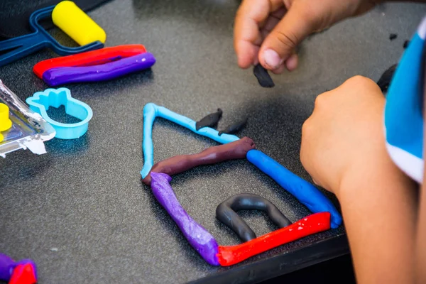 Niños jugando con arcilla de modelado Imagen de stock