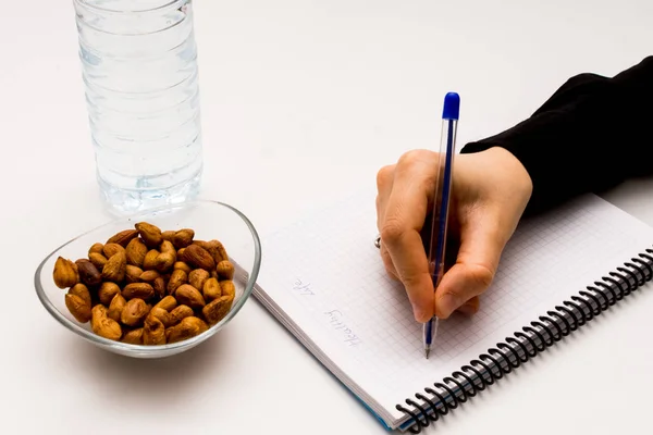 Person writing information in the notebook — Stock Photo, Image