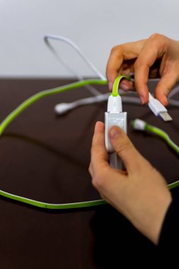 İki kablo ve telefon şarj cihazı tutan kız 