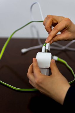 İki kablo ve telefon şarj cihazı tutan kız 