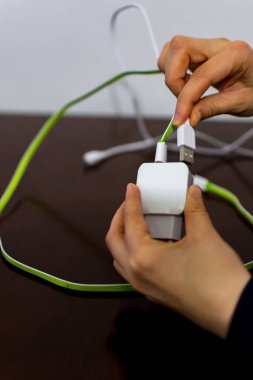 İki kablo ve telefon şarj cihazı tutan kız 