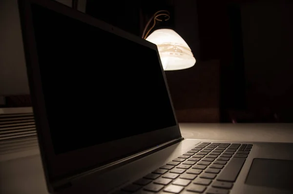 Laptop e lâmpada na mesa no local de trabalho Imagens De Bancos De Imagens Sem Royalties