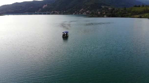 Een kleine boot met toeristen rijden op de Jablanica meer — Stockvideo