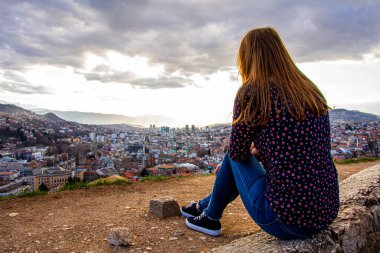 Kız oturuyor ve Sarı Kale 'den Bosna-Hersek' in başkentine bakıyor