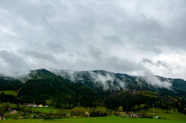 Avusturya 'daki dağın altındaki küçük köyün güzel manzarası