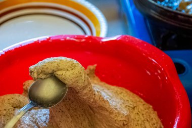 Kahvaltıda börek pişirmek için kaşık kaşık buğday ve karabuğday hamuru alıyoruz.