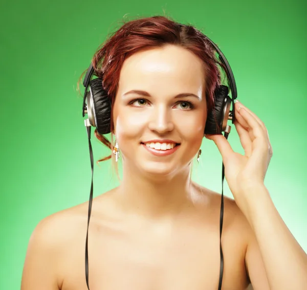 Young happy woman listening to music with headhones — Stock Photo, Image