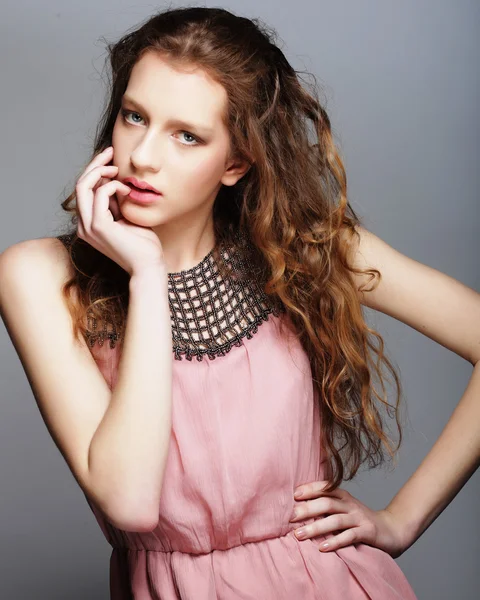 Fashion meisje model poseren op grijze achtergrond in de studio. — Stockfoto